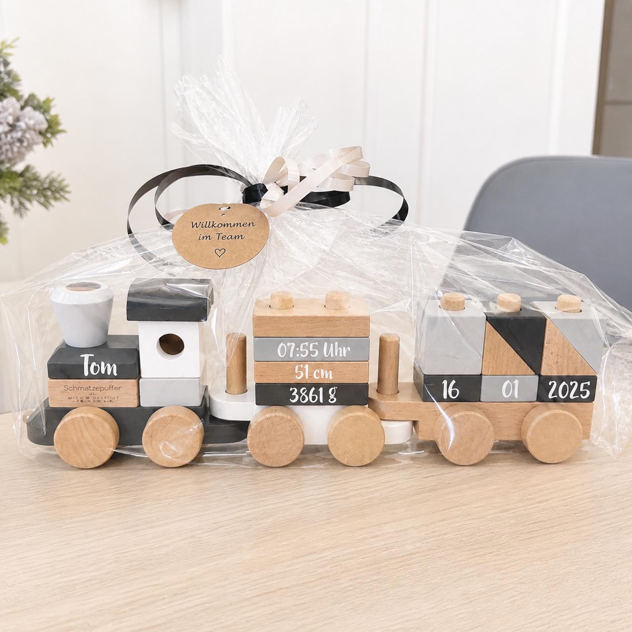Personalisierter Holzzug als Geschenk zur Geburt für Mitarbeiter liebevoll verpackt mit Schleife und Karte Willkommen im Team
