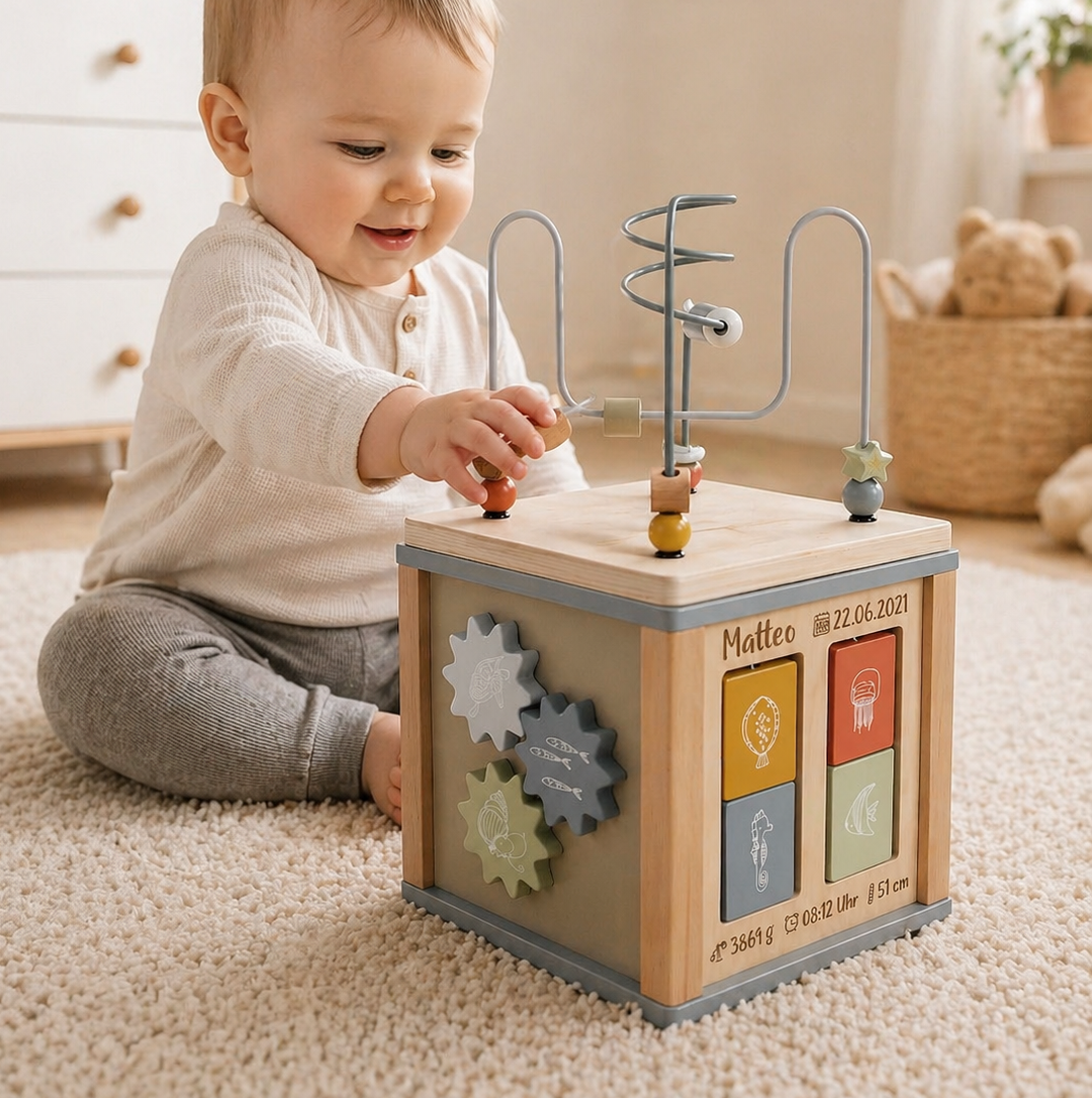Baby spielt mit personalisiertem Motorikwürfel aus Holz mit Name Matteo – Geschenk zur Geburt