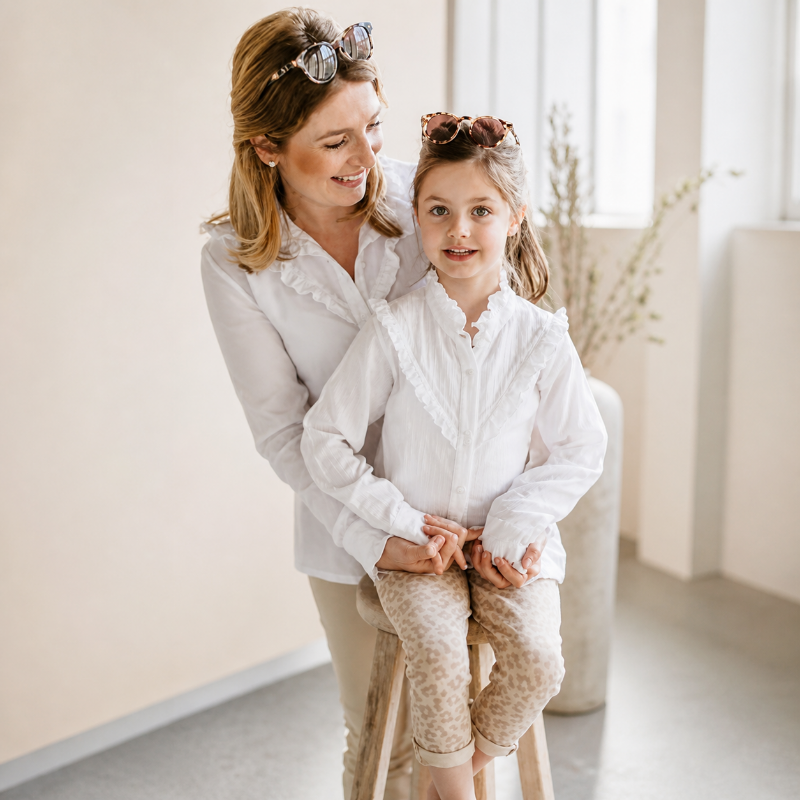 Kind trägt weiße Bluse mit Rüschen – stilvolles Outfit für Mädchen mit hochwertiger Kinderkleidung