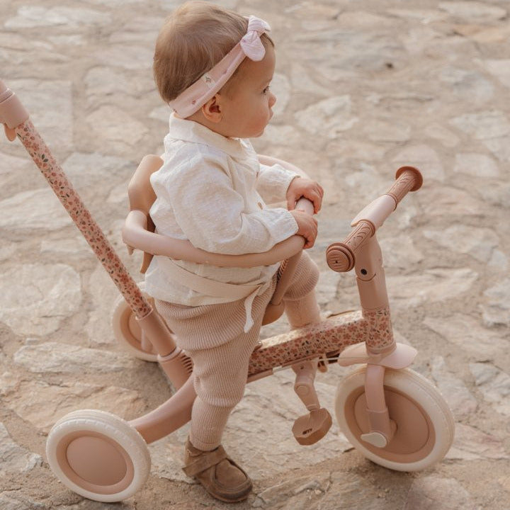 Kleinkind auf mitwachsendem 4-in-1 Dreirad Fairy Floral Rosa mit Schubstange und Sicherheitsring. Hochwertiges Kinderdreirad für Kinder ab 1 Jahr, das Sicherheit, Komfort und spielerische Förderung von Balance und Motorik vereint.